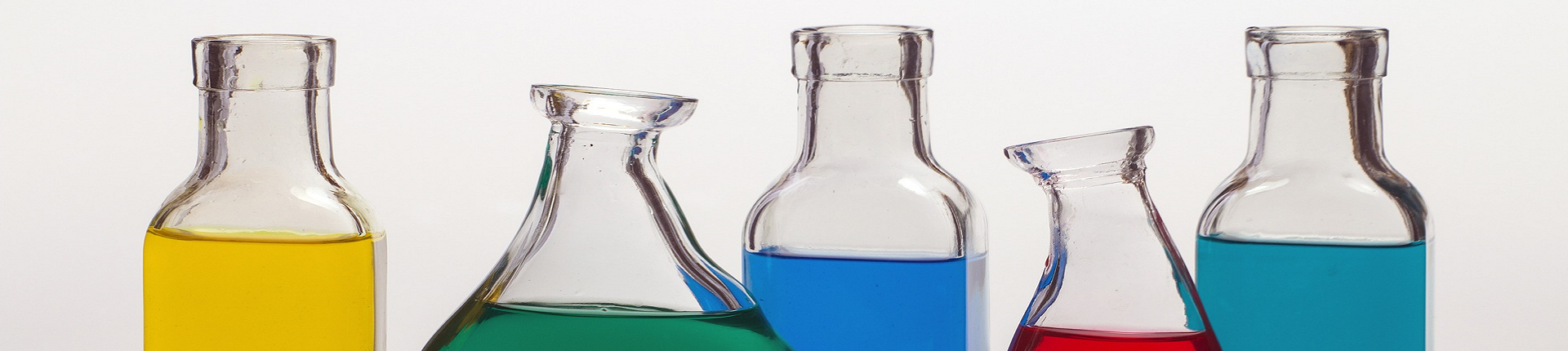 fünf Glasflaschen mit bunten Flüssigkeiten gefüllt