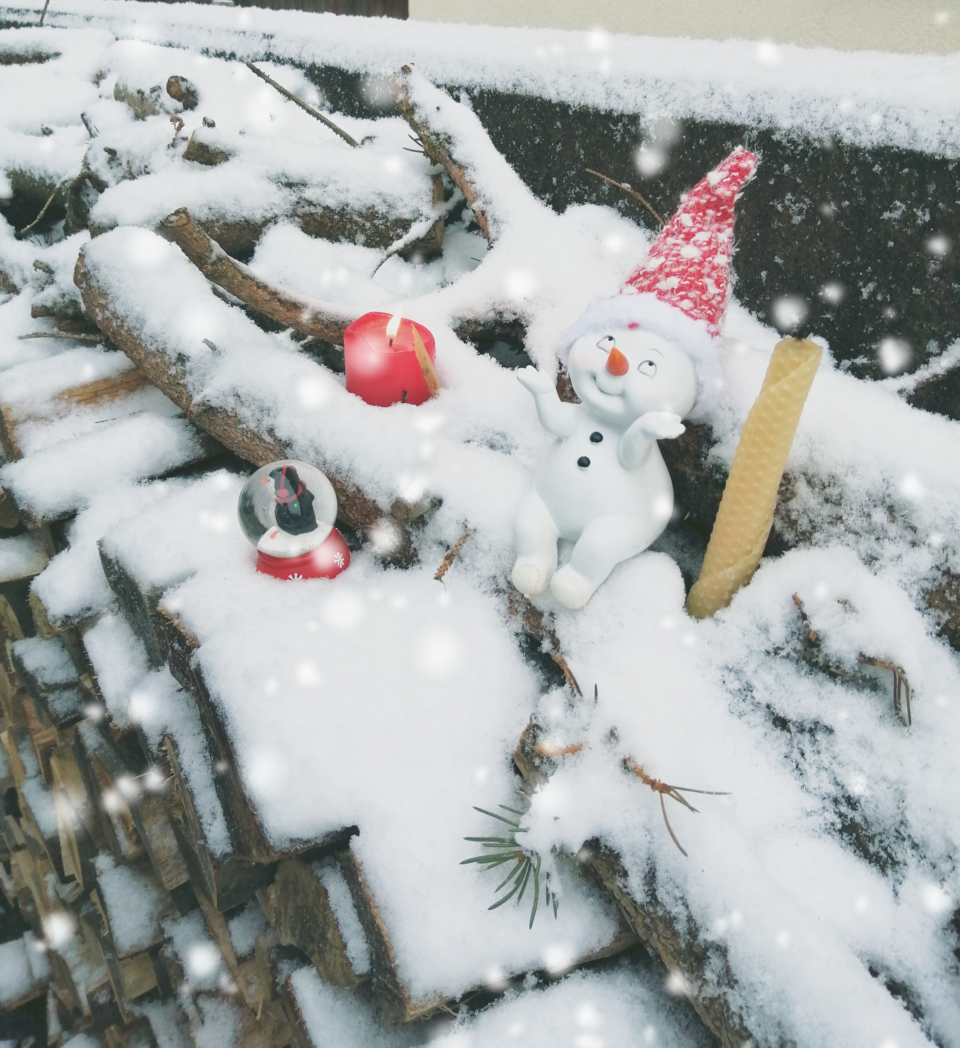 Weihnachtswichtel sitz auf verschneitem Holzstoß